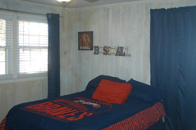 bedroom with ornamental molding and multiple windows