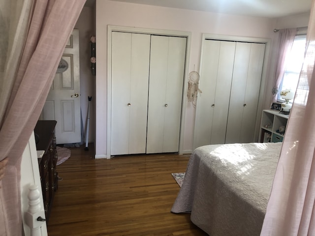 bedroom featuring dark wood-type flooring and multiple closets