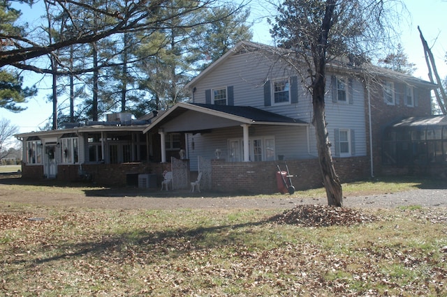 view of front facade with a sunroom and a front lawn