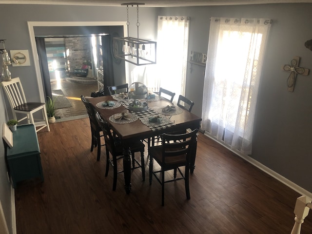 dining area with dark hardwood / wood-style flooring and a chandelier