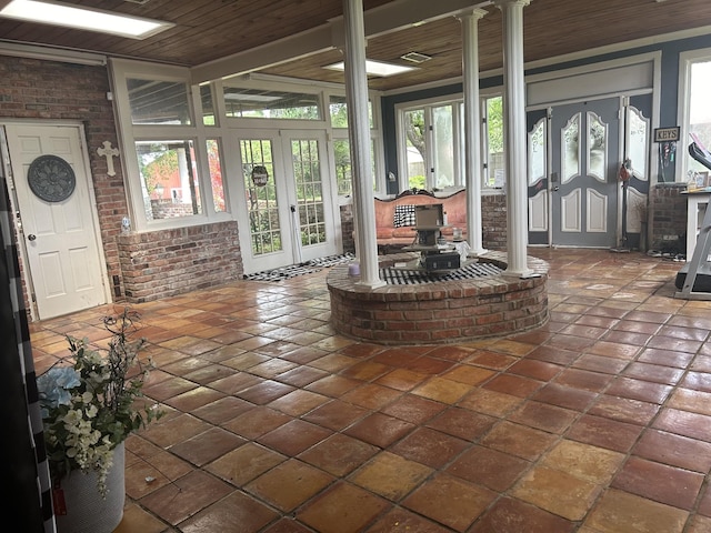 unfurnished sunroom with decorative columns, french doors, and wood ceiling