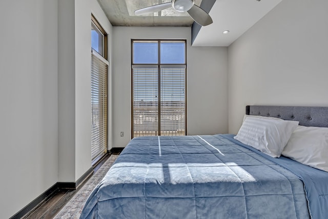 bedroom featuring multiple windows, dark hardwood / wood-style floors, and ceiling fan