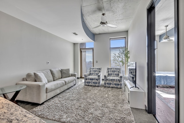 living room featuring dark wood-type flooring and ceiling fan