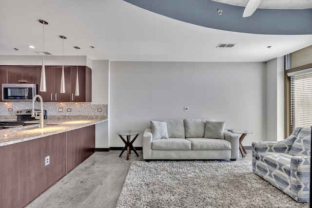 living room featuring ceiling fan and sink