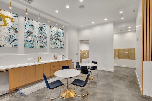 kitchen featuring a towering ceiling, rail lighting, and fridge