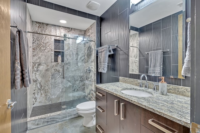 bathroom featuring an enclosed shower, tile flooring, vanity with extensive cabinet space, and toilet