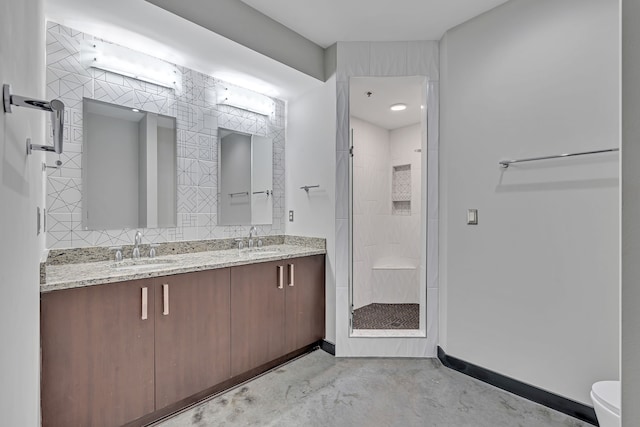 bathroom featuring concrete flooring, double sink vanity, toilet, and a tile shower