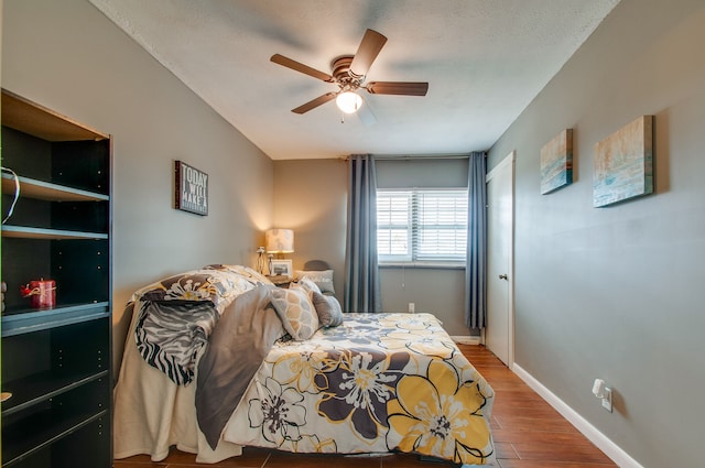 bedroom with ceiling fan, hardwood / wood-style flooring, and a textured ceiling