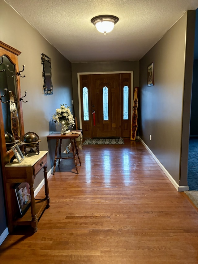 foyer entrance with a textured ceiling and hardwood / wood-style flooring