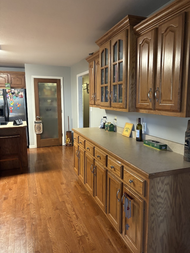 kitchen with hardwood / wood-style floors and stainless steel fridge with ice dispenser