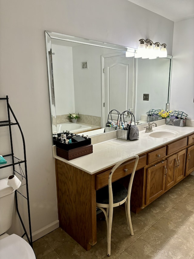 bathroom with tile flooring, a bath to relax in, vanity, and toilet