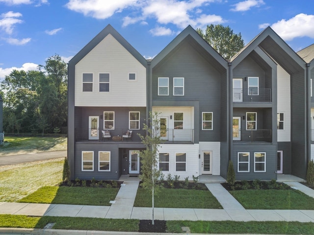 view of front of home featuring a balcony and a front yard