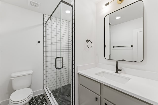 bathroom featuring tile floors, toilet, large vanity, and an enclosed shower