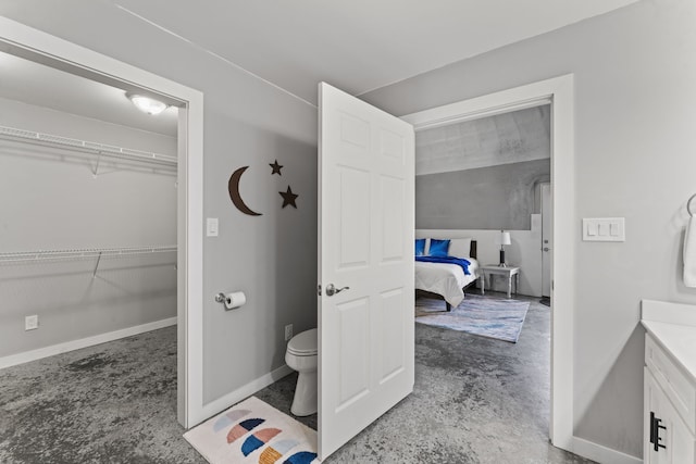 bathroom featuring vanity, toilet, and concrete flooring