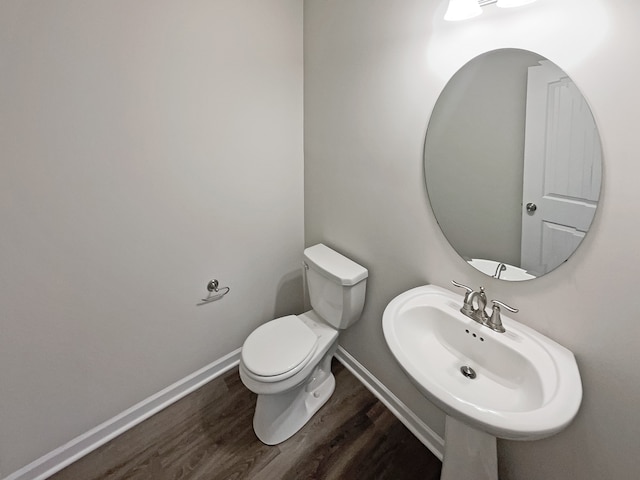 bathroom with toilet, hardwood / wood-style flooring, and sink