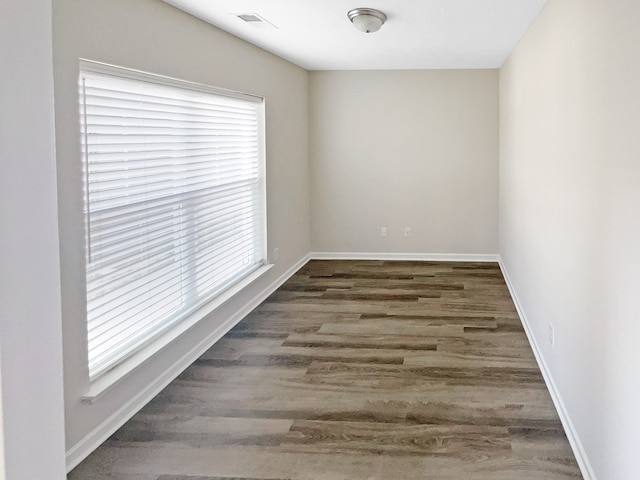 spare room featuring plenty of natural light and dark hardwood / wood-style floors