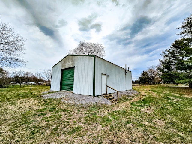 view of outdoor structure featuring a garage and a lawn