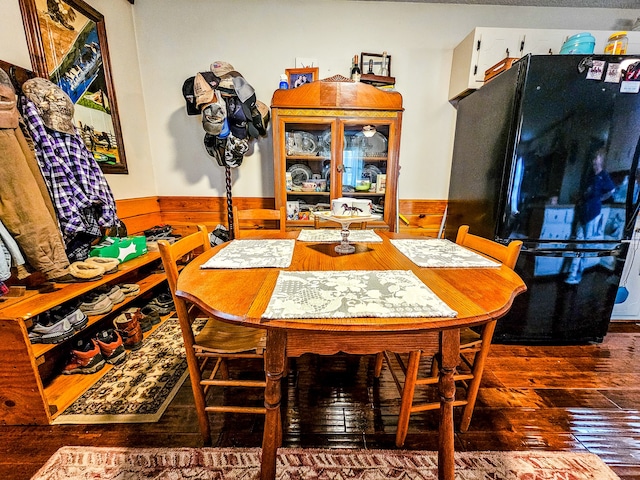 dining room featuring wooden walls and dark hardwood / wood-style floors