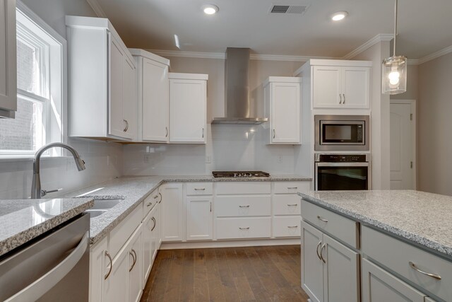 7112 Maddenwood Ln, Hermitage, TN 37076 - kitchen featuring stainless steel appliances, wall chimney exhaust hood, dark wood-style flooring, ornamental molding, and a sink