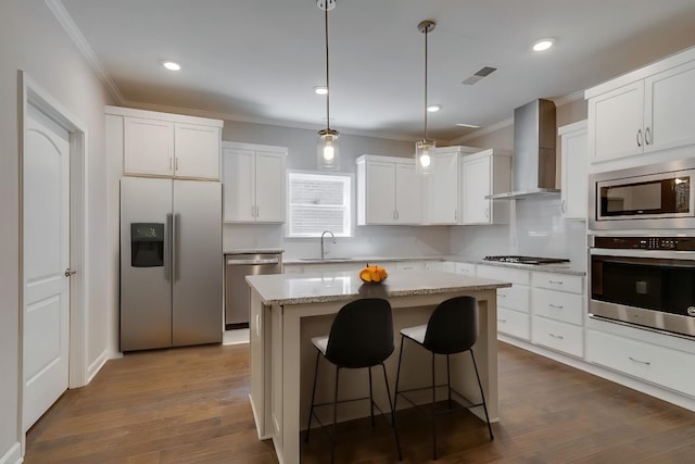 7112 Maddenwood Ln, Hermitage, TN 37076 - kitchen with stainless steel appliances, wall chimney exhaust hood, ornamental molding, a center island, and white cabinets