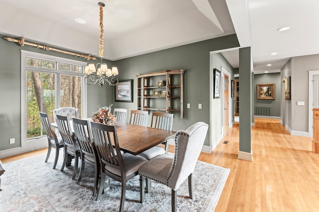 dining area featuring light wood-type flooring and a chandelier