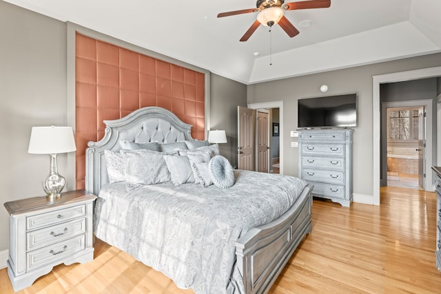 bedroom with light wood-type flooring, ceiling fan, and ensuite bath