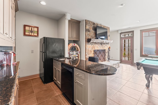 kitchen with pool table, light tile patterned floors, dark stone countertops, black appliances, and kitchen peninsula