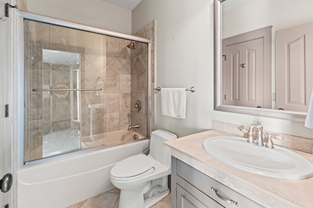 full bathroom featuring vanity, toilet, bath / shower combo with glass door, and tile patterned floors