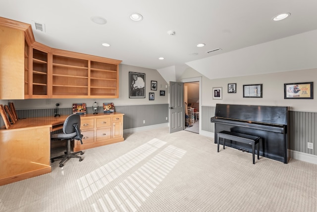 home office featuring built in desk, vaulted ceiling, and light carpet