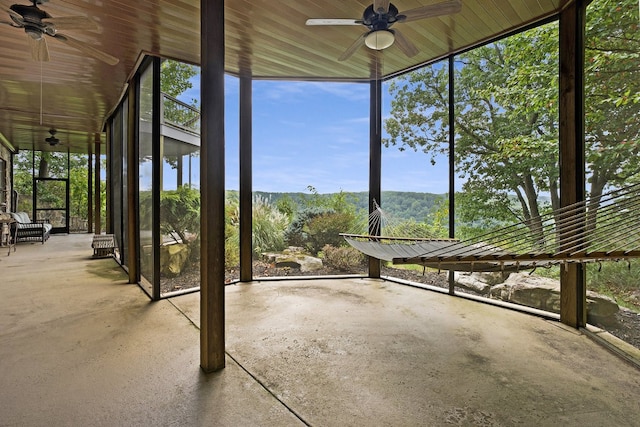 unfurnished sunroom with ceiling fan