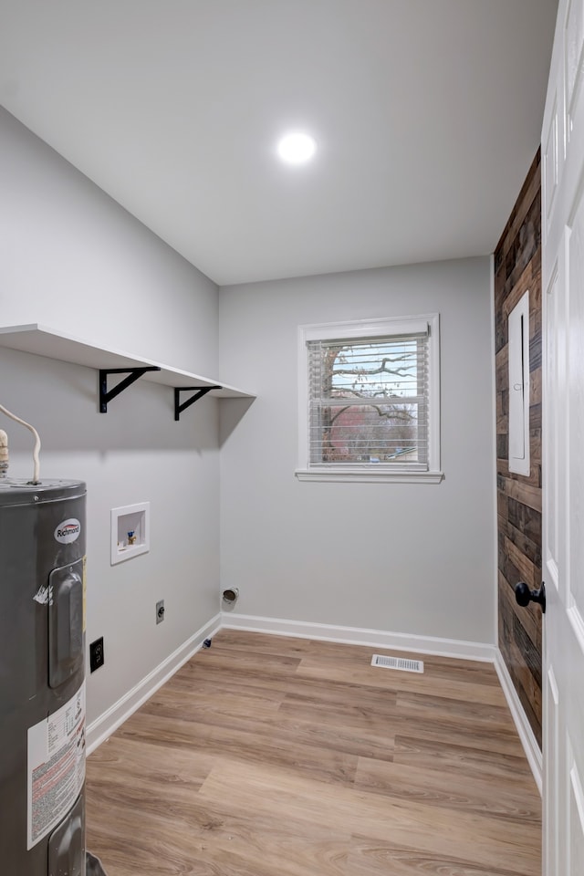 laundry area with water heater, light wood-type flooring, hookup for an electric dryer, and hookup for a washing machine