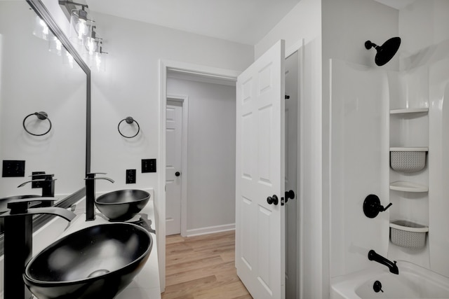 bathroom with shower / bathing tub combination, double sink vanity, and hardwood / wood-style flooring