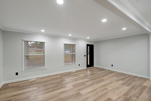 spare room featuring crown molding and light hardwood / wood-style floors