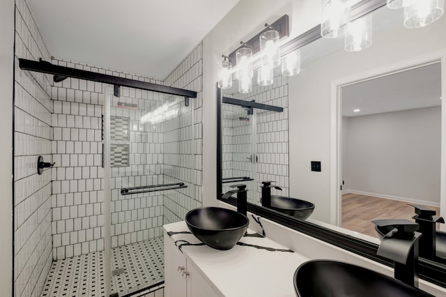 bathroom featuring walk in shower, double sink vanity, and hardwood / wood-style flooring