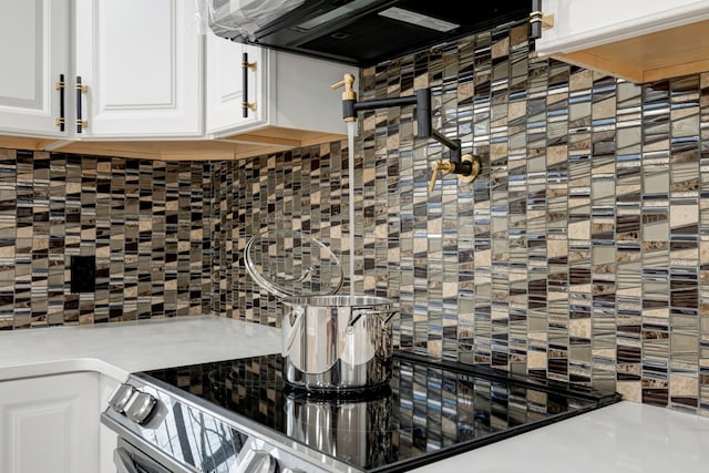 kitchen featuring fume extractor, tasteful backsplash, and white cabinetry