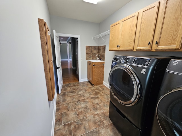 laundry area featuring sink, washing machine and clothes dryer, cabinets, and wood-type flooring