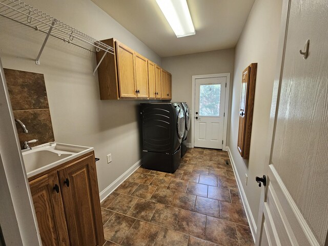 laundry room featuring sink, dark tile patterned floors, cabinets, and washer and dryer