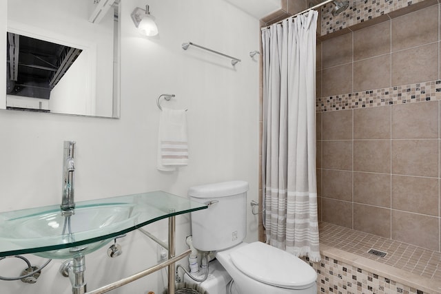 bathroom with curtained shower, sink, and toilet