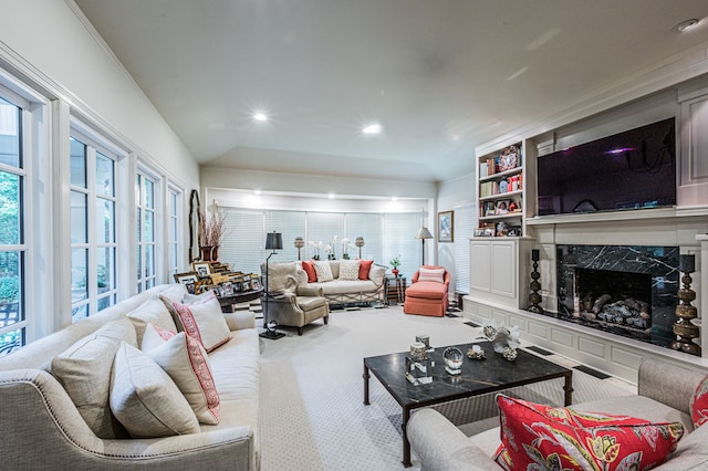 living room featuring a fireplace, built in shelves, and carpet