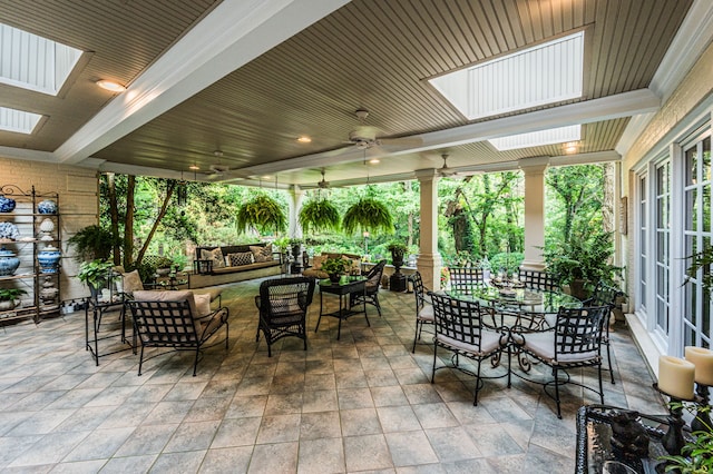 sunroom with ceiling fan and a skylight