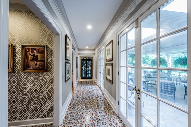 hallway with ornamental molding, light tile floors, and french doors