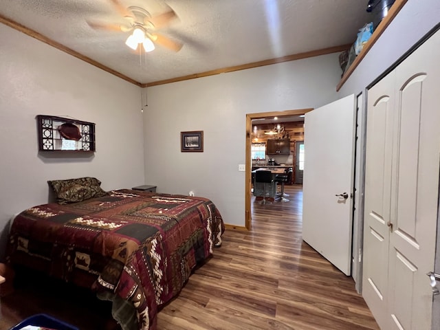 bedroom featuring ceiling fan, ornamental molding, a textured ceiling, a closet, and hardwood / wood-style floors