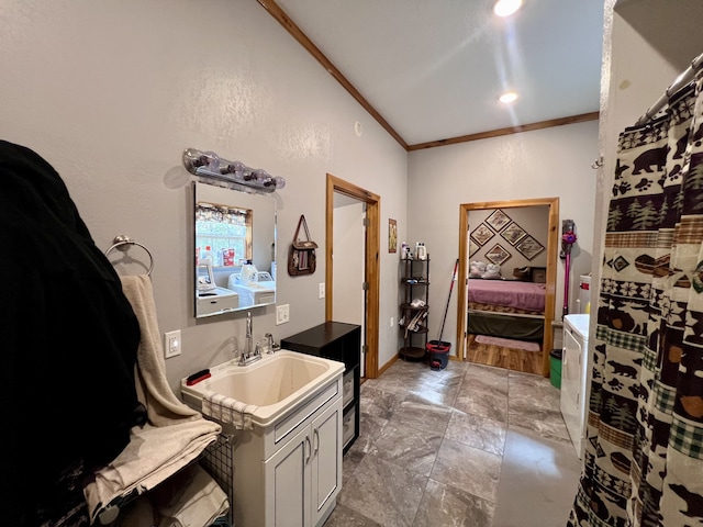 bathroom featuring vanity, ornamental molding, and washing machine and clothes dryer