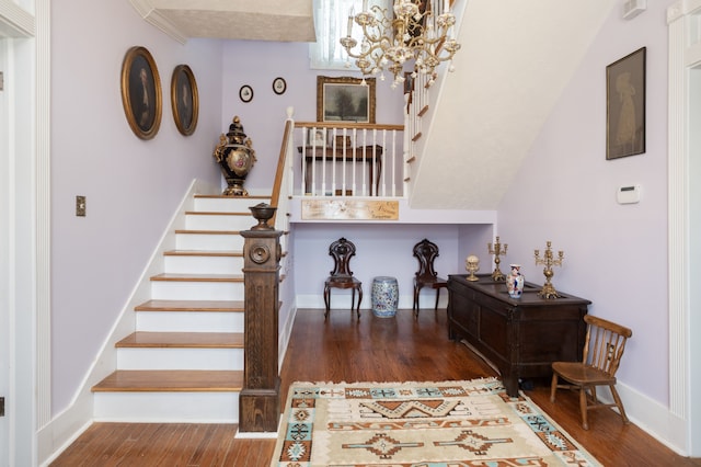 entrance foyer with an inviting chandelier, dark hardwood / wood-style floors, and ornamental molding