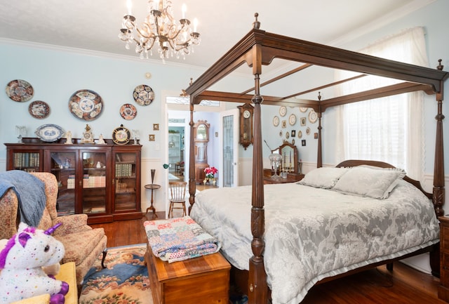 bedroom with dark wood-type flooring, a notable chandelier, and crown molding
