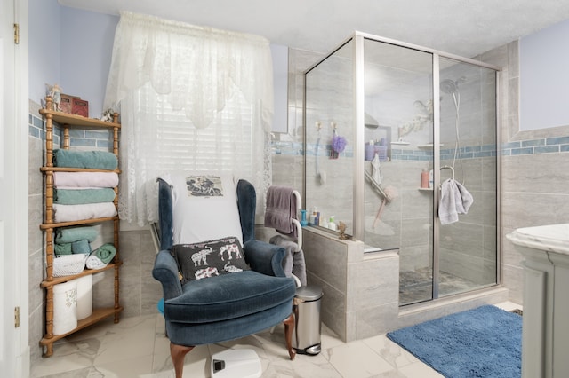 bathroom with tile walls, tile floors, and a shower with door