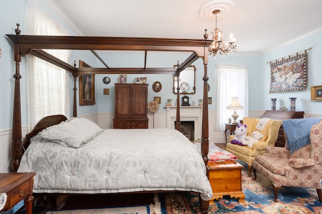bedroom featuring an inviting chandelier, multiple windows, and ornamental molding
