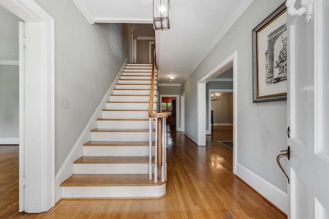 staircase with crown molding and hardwood / wood-style flooring