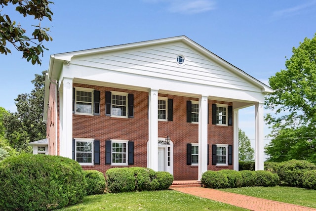 neoclassical / greek revival house with a front yard and a porch