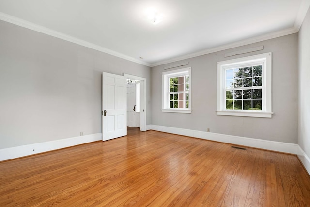 empty room with ornamental molding and wood-type flooring